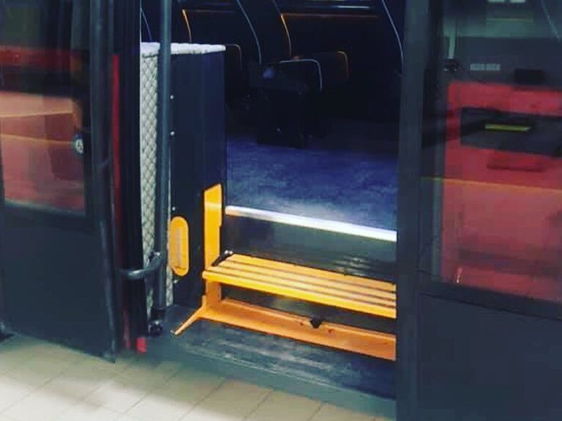 Midibüsün yan kapısında turuncu basamaklı Tümsan basamak tipi lift