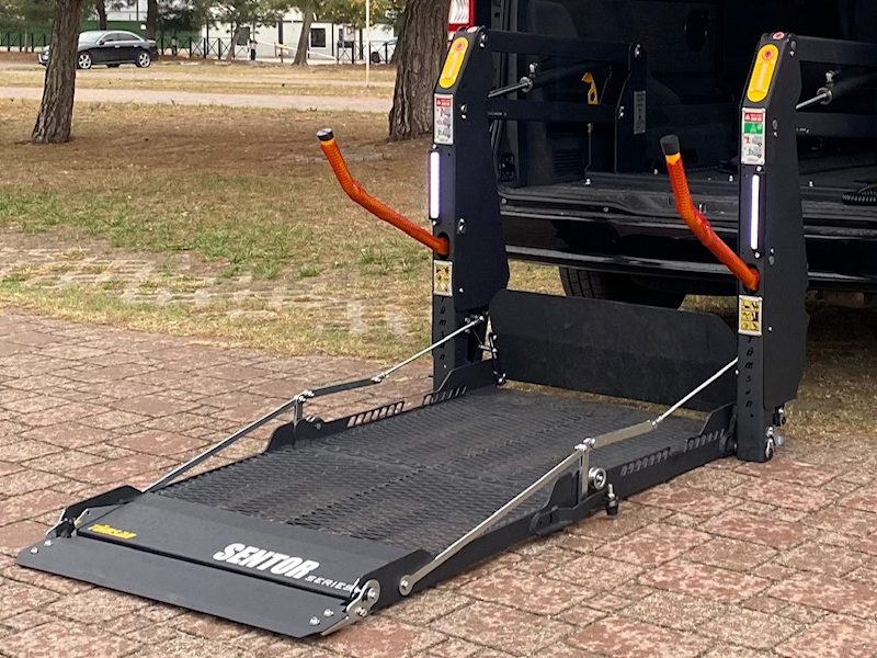Siyah minivanın arka kapısında zemine inmiş Tümsan SENTOR serisi çift kollu lift